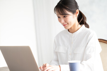Beautiful Asian woman working on computer with her head down