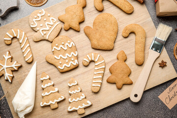 Board with Christmas gingerbread cookies on dark background