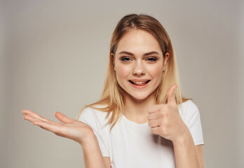 beautiful blonde in a white positive posing joy smile light background