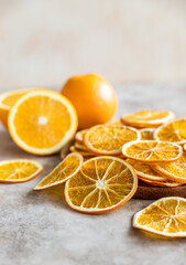 Natural dried oranges on light concrete background. Sliced and dried citrus fruit.
