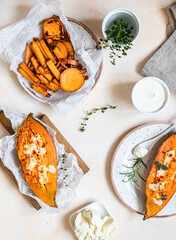 Baked sweet potatoes with mozzarella, herbs and creamy dip on concrete background.