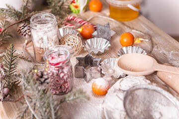 Obraz na płótnie Canvas Kitchen rolling pin and wooden spoon appliances utensils flour cook present culinary dinner tangerines, New Year evening, Christmas decorated home. Greeting congratulating with holiday 