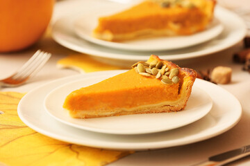Plates with piece of delicious pumpkin pie on table