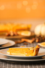 Plates with piece of delicious pumpkin pie on table