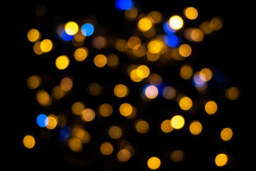Fototapeta na wymiar Perfect bokeh for a festive New Year and Christmas background. Defocused abstract yellow and blue light circles. Bokeh is distributed throughout the frame