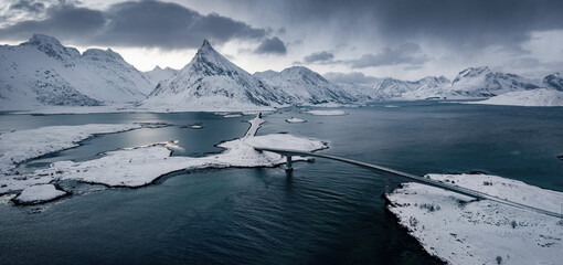 Dramatic winter scene of Norway, Europe. Panoramic morning view of Lofoten Islands archipelago. Photography of Fredvang bridge with Volandstind peak on background. Black and white filter toned.