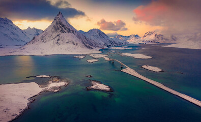 Naklejka premium Unbelievable winter sunrise on Norway, Europe. Gorgeous morning scene of Lofoten Islands archipelago. Photography of Fredvang bridge with Volandstind peak on background.