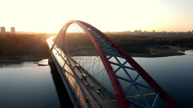 Road bridge against the backdrop of a spectacular sunset. Transport links. Horizontal flyby of a massive structure. Architectural automobile buildings