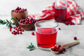 Fototapeta na wymiar Glass with healthy cranberry juice on light background