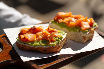 Closeup on two appetizing bruschettas with avocado and salmon