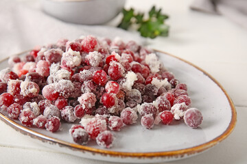 Plate with sugared cranberry on table, closeup