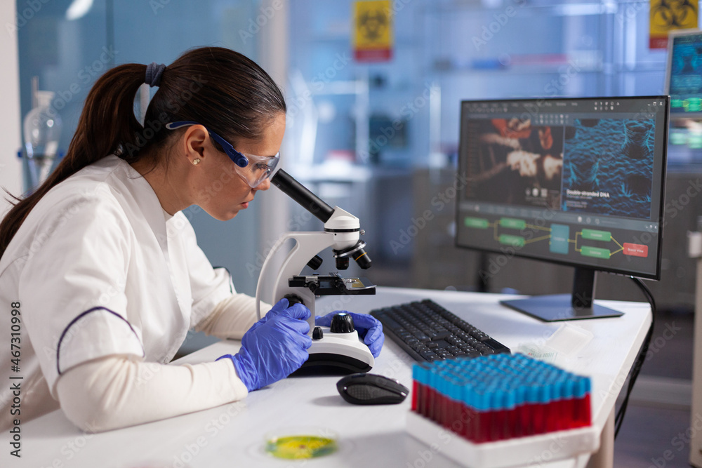Wall mural specialist doctor analyzing virus expertise using microscope during biomedical experiment in hospita