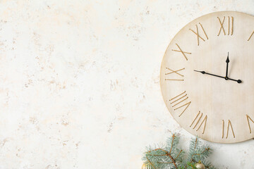 Stylish interior with Christmas tree and wooden clock on light wall