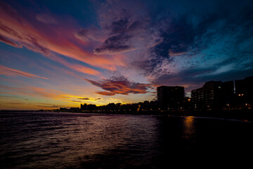 Atardecer con cielo espectacular. Paseo marítimo. Costa urbana. Playa de la ciudad con cielo bonito. Atardecer crepuscular.