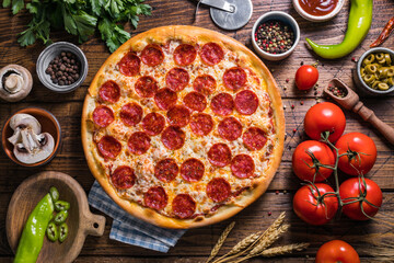 Homemade pepperoni pizza on a wooden table, top view, close-up