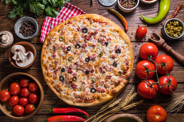 Homemade pizza with jalapeno peppers on a wooden background.