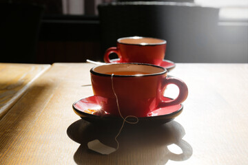 Cups of hot tea on wooden table