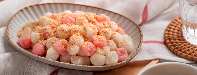 Deep-fried red and white tangyuan with peanut powder.