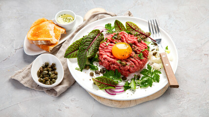 Fototapeta na wymiar Beef steak tartare on light background. French cuisine concept.