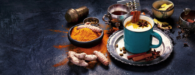 Healthy turmeric golden milk on dark background.