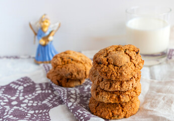 Oatmeal cookies with milk on white background and linen towel with purple snowflakes
