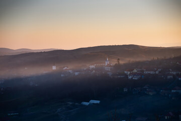  Sic, Romania. Foggy sunset over the small village, Transylvania.