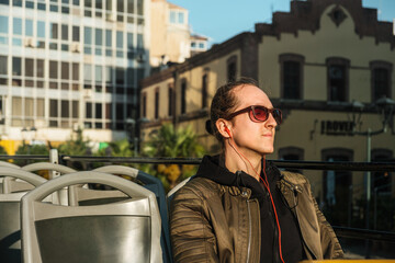 Young man on double-decker sightseeing bus in Thessaloniki, Greece
