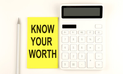 text KNOW YOUR WORTH on yellow sticker, next to pen and calculator