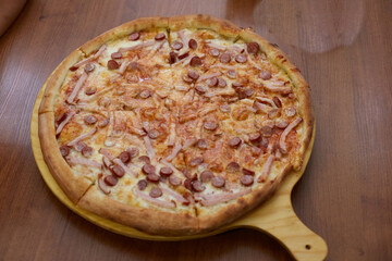 Delicious salami pizza is on the table in the pizzeria
