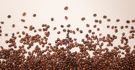 Fototapeta premium Spilled coffee on light brown background. Lots of coffee. Background. Coffee beans.