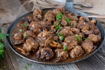 Meatballs with mushroom sauce in a rustic pan