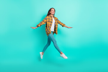 Fototapeta na wymiar Full size photo of mature joyful brunette lady run wear shirt jeans sneakers isolated on turquoise background