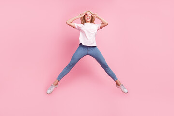Fototapeta na wymiar Full body photo of funny young blond lady jump wear spectacles t-shirt jeans sneakers isolated on pink background