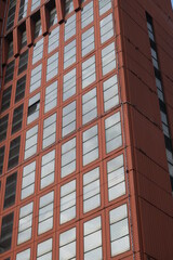 Packaged building. Skyscraper covered with safety net.A modern tower block with glass windows and covered with red tiles that stand out from the walls. Cagliari, Sardinia,  Italy.