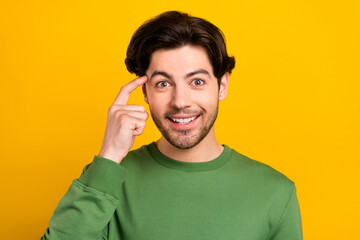 Photo of smart excited genius positive guy finger temple wear green pullover isolated yellow color background