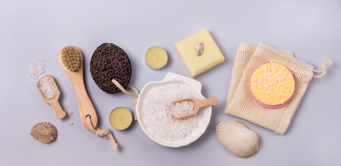 Flay Lay Sea Salt Aroma Candles Face Sponges Bamboo Face Brush Plumeria Flower Natural Soap Scoop with Salt Shell Pumice Pink Background SPA concept Top View Horizontal Wellness