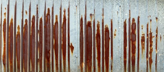 long rusty metal veneer sheet plank with vertical  rust marks - industrial dirty background