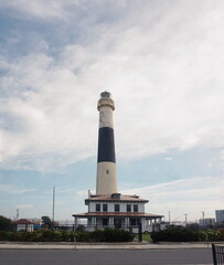 Naklejka premium Black And White Lighthouse with Blue Sky and White Clouds