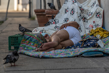homeless man sleeping on the pavement