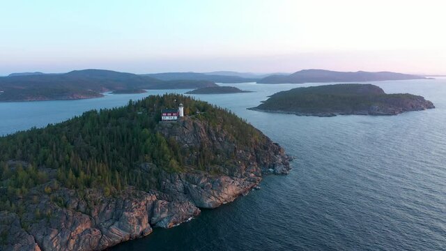 Isolated remote lighthouse on high cliff i dramatic coastal landscape in High Coast of Sween