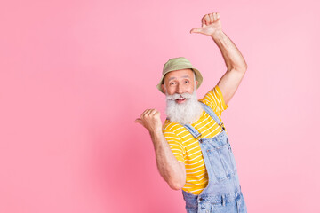 Portrait of attractive cheerful bearded man showing copy space ad offer isolated over pink pastel color background