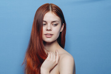 Fototapeta premium pretty woman combing hair bare shoulders hair care