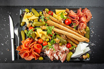 Charcuterie Board with Various Pickles, Cheeses, and Meats - Cucumbers, Olives, Cheese Cubes,...