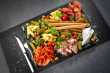 Charcuterie Board with Various Pickles, Cheeses, and Meats - Cucumbers, Olives, Cheese Cubes,...