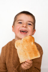 Children and gluten. Preschool boy with toasted bread. Gluten intolerance by kids. Copy space on...