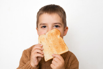 Children and gluten. Preschool boy with toasted bread. Gluten intolerance by kids. Copy space on...