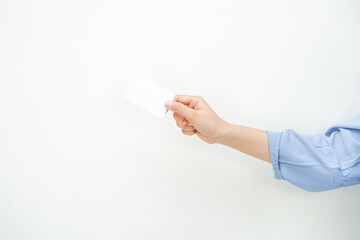 a hand of a lady wearing a long blue shirt holding an empty white space as it's a card. a mockup that is suitable for business or identity mockup use.