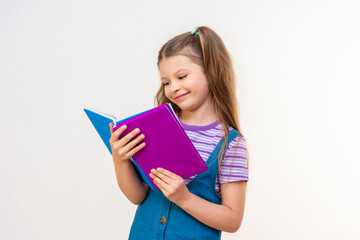 A schoolgirl reads an interesting story in a book on a white background.