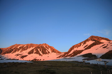 夕日に赤く染まる立山と浄土山