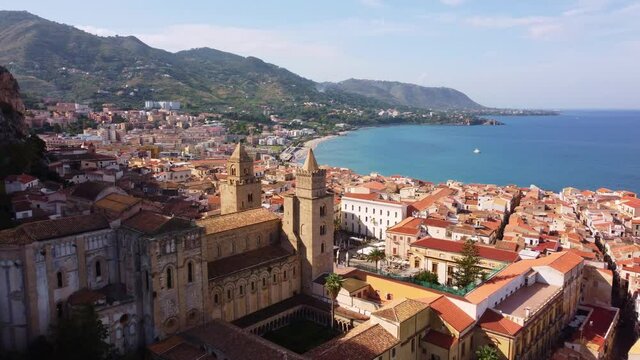 Aerial drone footage of the famous Cefalu old town with its Norman mediveval cathedral in Sicily, Italy. Shot with a tilt down motion